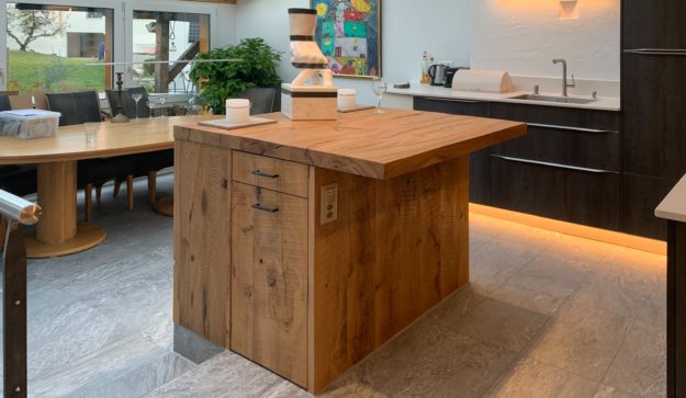 Mein Küchenatelier zeigt ein Bild einer schwarzen Referenz-Küche mit Inseltheke aus Holz