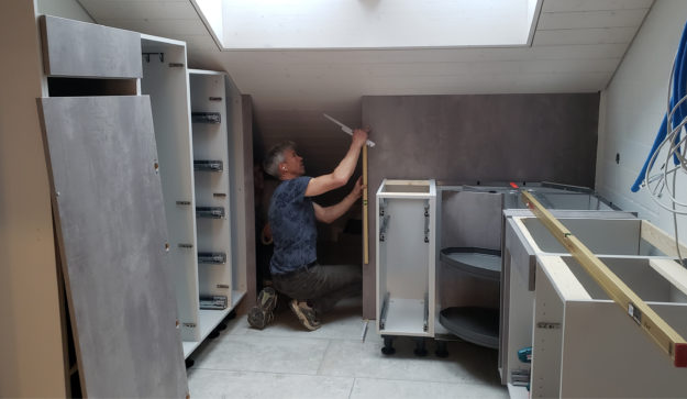 Mein Küchenatelier zeigt ein Bild von der Montage von Schränken einer Küche in betongrau