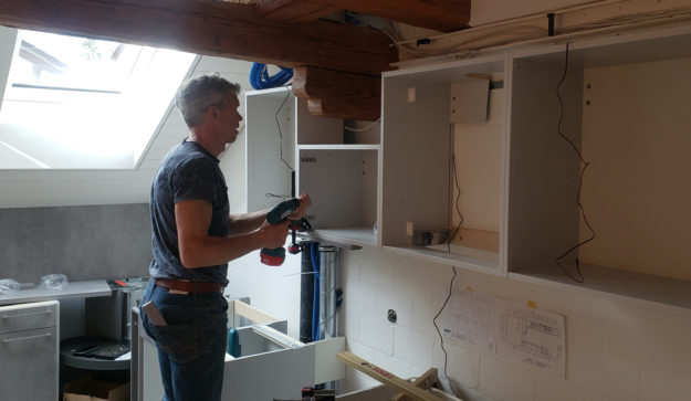 Mein Küchenatelier zeigt ein Bild von der Montage von Schränken einer Küche in betongrau